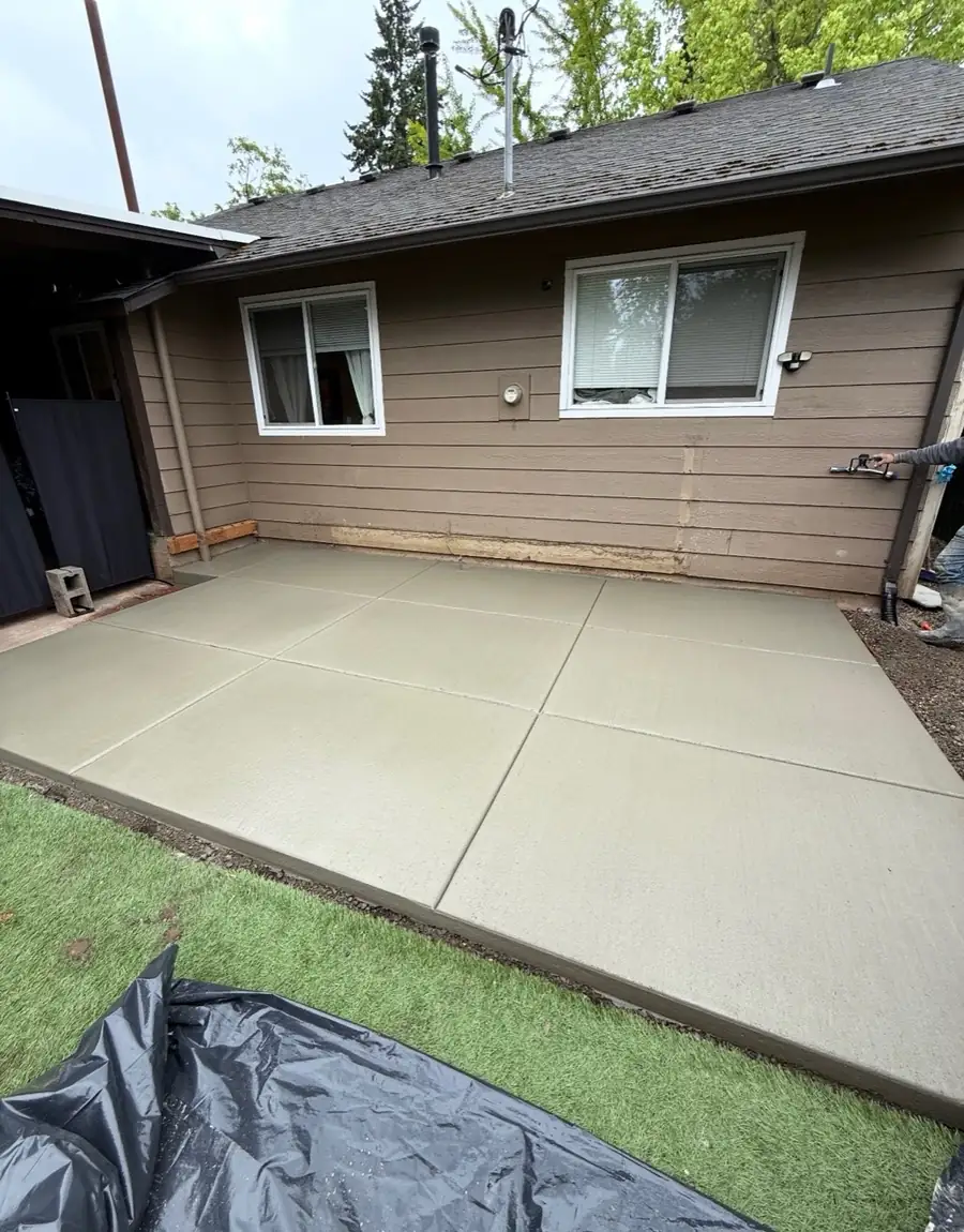 Finished multi-panel concrete patio behind a house